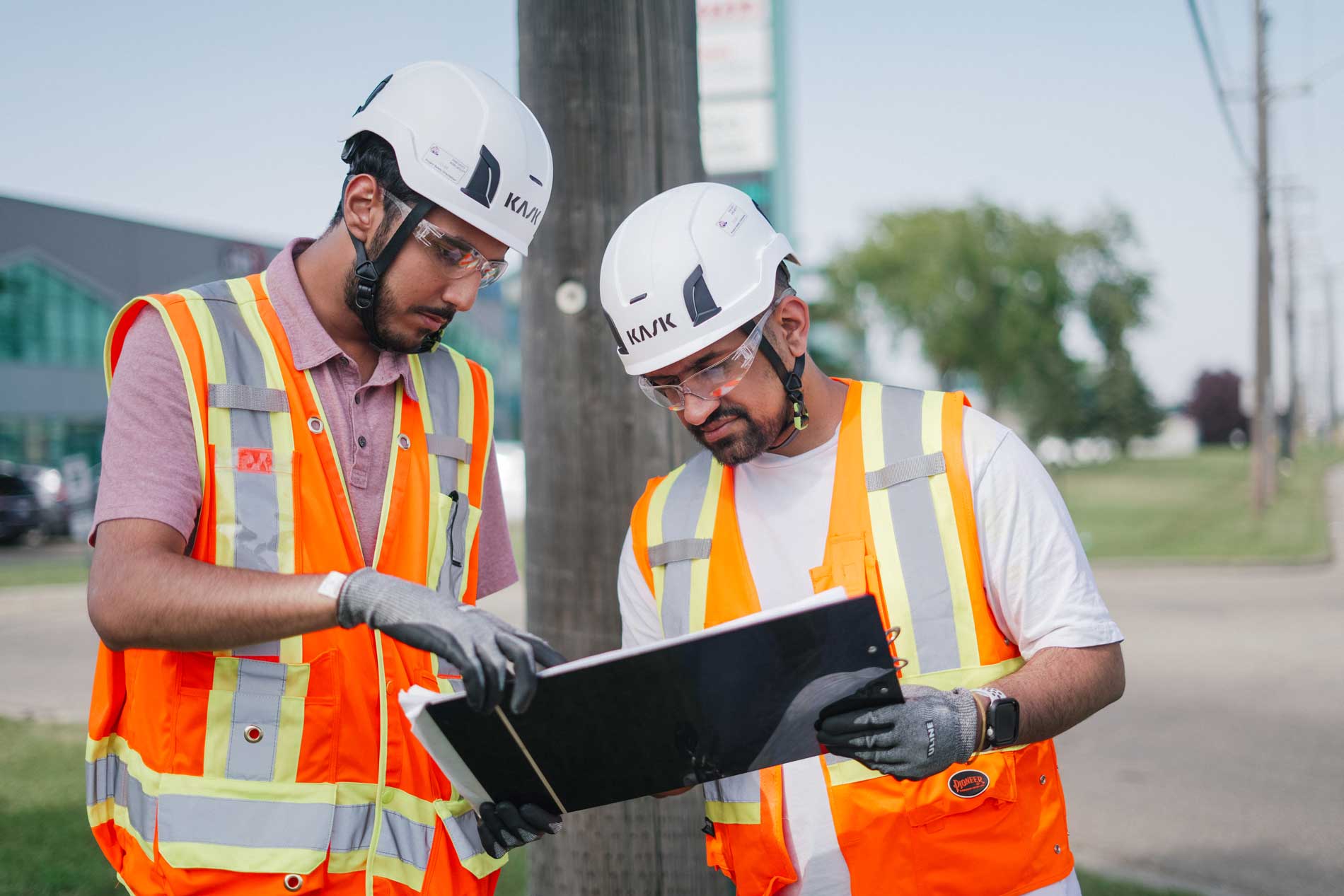Construction workers reviewing plans outdoors.